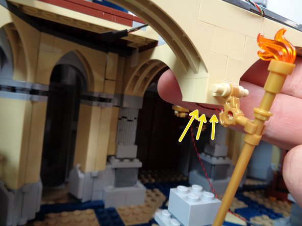 As shown in the second photo, carefully remove the center section of one of the columns behind the torch wall mounts.