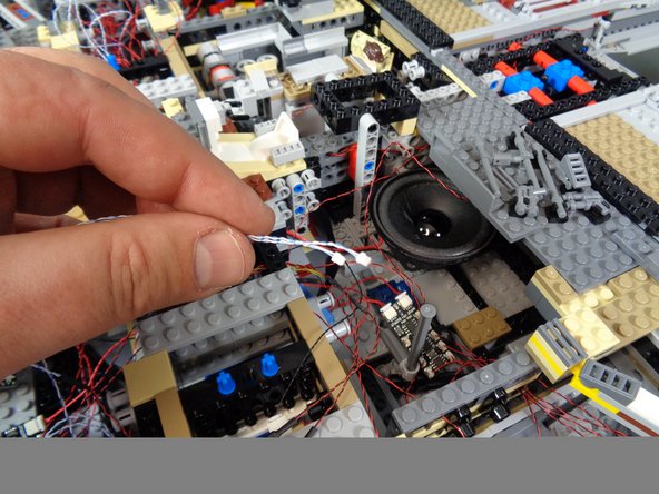 As shown in the photos for this step, continue routing the laser light wires up toward the second BRANCH09X adapter board.
