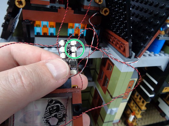 Now, connect the red LED light to plug #5 on the third BRANCH06X adapter board as shown by the green circle in the second photo for this step.