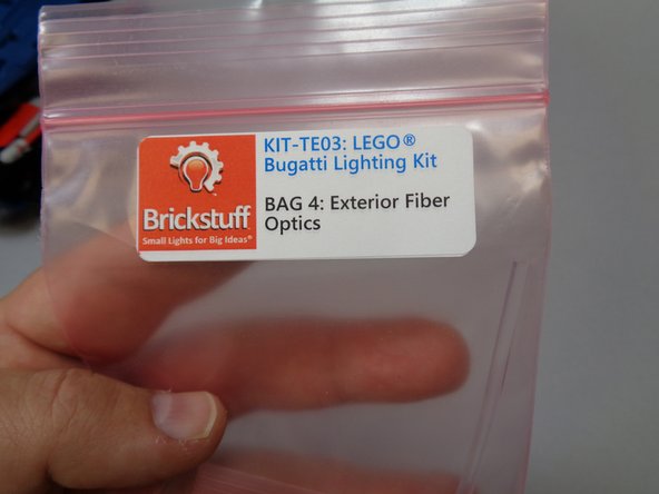 Take Bag 4 (labeled &quot;Exterior Fiber Optics&quot;) and carefully remove the long clear fiber optic tube and two light bluish gray &quot;blasters&quot; with red LEDs pre-mounted.