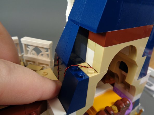 As shown in the third photo, re-attach the blue roof slope piece.