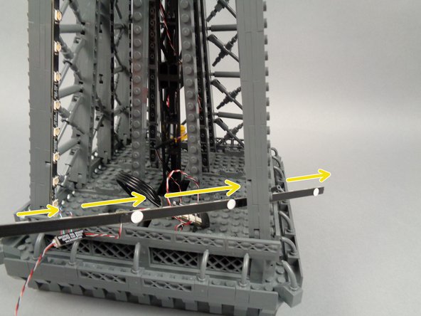 To prepare, feed the strips connected to plug #2 on the adapter board through the center of the next pillar as shown by the yellow arrows in the second photo.