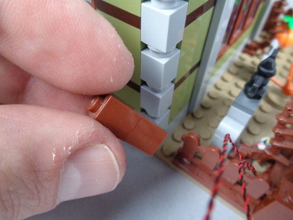 As shown in the first photo for this step, remove the left rear fence post closest to the side of the mansion.