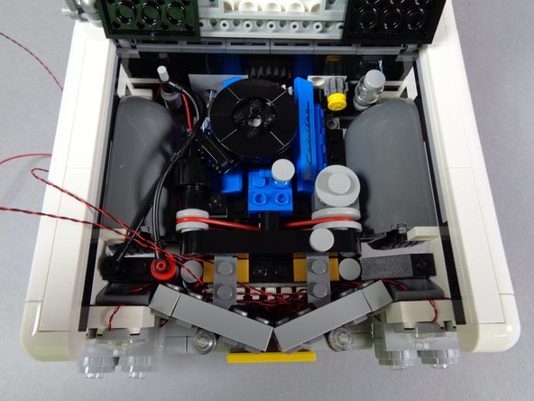 Your grille should now look like the grille in the second photo for this step.  If necessary, coil up any headlight wires behind the grille that may still be visible.
