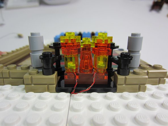 Complete step 13 as shown in the build instructions, but substitute 2 Trans-Yellow 1x1 round bricks in the base.  Insert 2 sanded Micro Light Boards into round bricks before mounting.