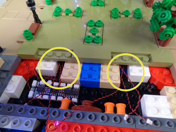 As shown in the first photo for this step, place Panel 1 back in its original location in the Tower Base.