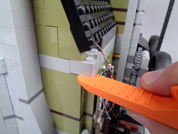 The yellow arrows in the third photo for this step show the gap in the wall you should create-- the gap should be large enough to pass the green LED light plug through.