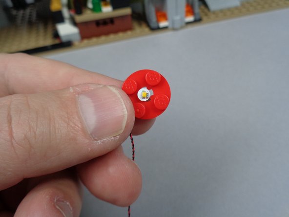 As shown in the second and third photos for this step, feed the plug for the LED light through the hole in the center of the jar base and pull the wire through so the LED light sits flat on the top of the plate.