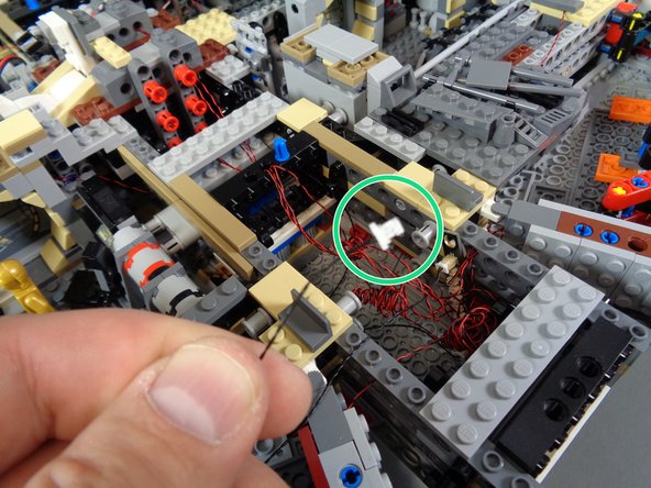 As shown by the green circle in the second photo, you should have one end of the 24&quot; connecting cable ready to route towards the back of the Falcon.