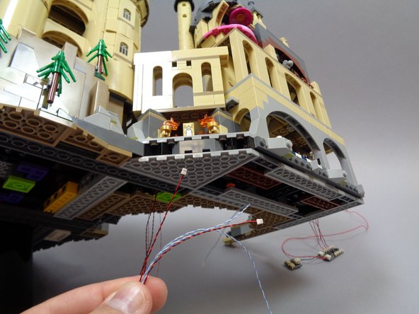 As shown in the second and third photos, take the four flame wires and carefully run them under the base as shown.