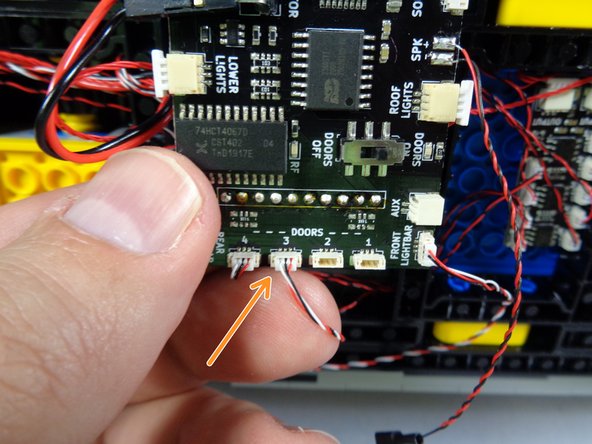 As shown in the second photo for this step, you can coil up any extra slack in the door switch wire.