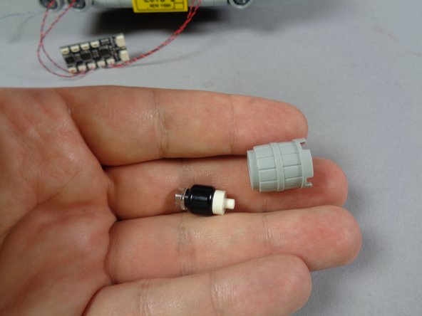 As shown in the first photo, remove the light bluish gray barrel assembly from the lower headlight row.