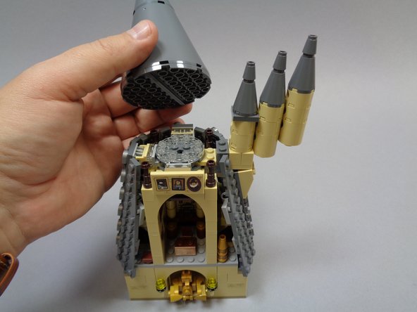 As shown in the second and third photos, remove the top of the tower and the section with the three smaller towers attached.