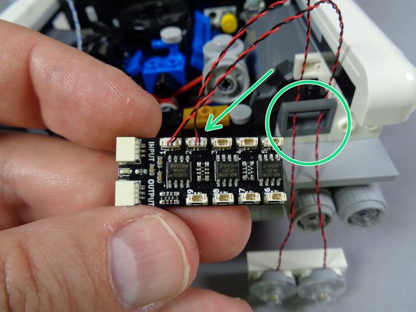 As shown by the orange arrow in the second photo for this step, connect the rightmost headlight to plug #1 on the BRANCH09X adapter board.