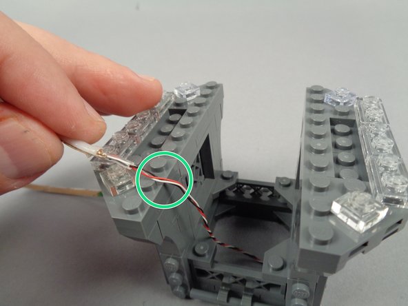 Position the end of the strip so the un-twisted section of wire is at the top edge as shown by the green circle in the second photo for this step.