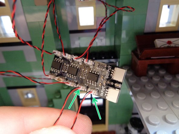 As shown by the two green arrows in the first photo, connect the two fireplace light wires to plugs #1 and #2 on the BRANCH09X adapter board.