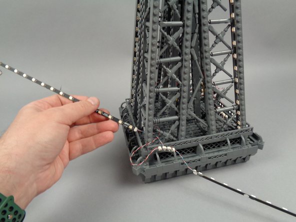 Continue passing the strips through the pillar until both the 17-LED strip and the 20-LED strip are through, as shown in the third photo.