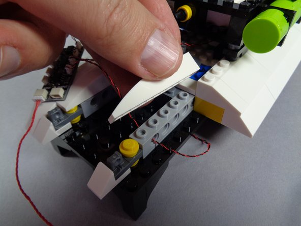 As shown by the green arrow in the second photo for this step, connect either end of the red wire to the plug on the BRANCH09X adapter that is labeled INPUT.