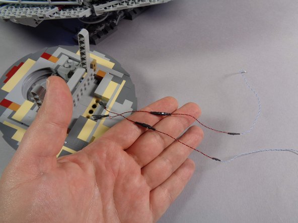 As shown in the third photo, connect the two conversion cables to the laser cannon LED light wires, making sure to match the green, red, or white dots on both sides of each connection.