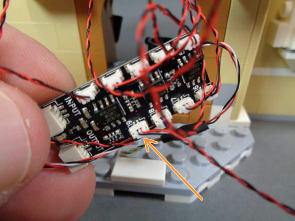 As shown by the orange arrow in the photo for this step, connect the stove light to plug #9 on the BRANCH09X adapter board.