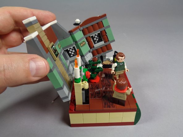 As shown in the photos for this step, you should be able to bend and then lift off the entire wall section of the house.