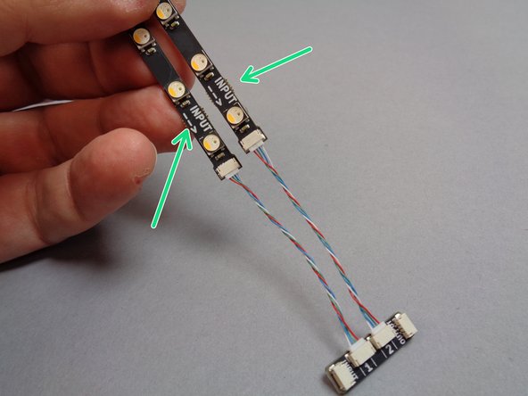 As shown in the photos for this step, connect the light strips in pairs to plugs #1 and #2 on the adapter boards.