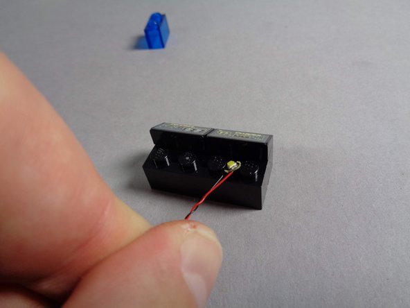 You should have two last cool white Pico LED lights in the Main Parts bag.  Remove both of them, and as shown in the first photo for this step, place one of the lights between the studs of the black brick behind the computer panel.