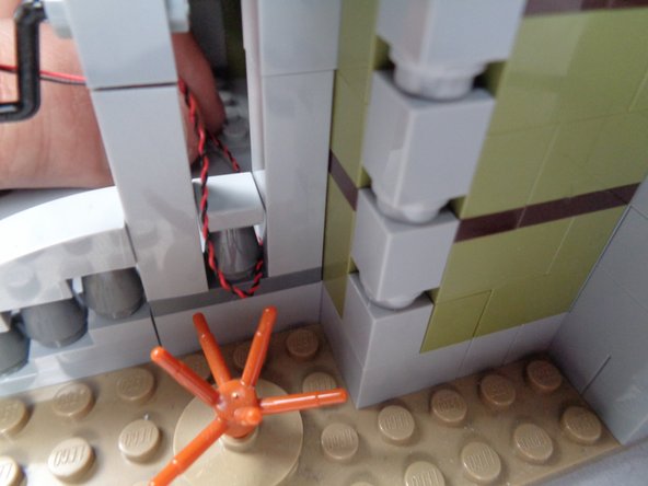 As shown in the photos for this step, run the light wire around the post under the railing and toward the front entryway.