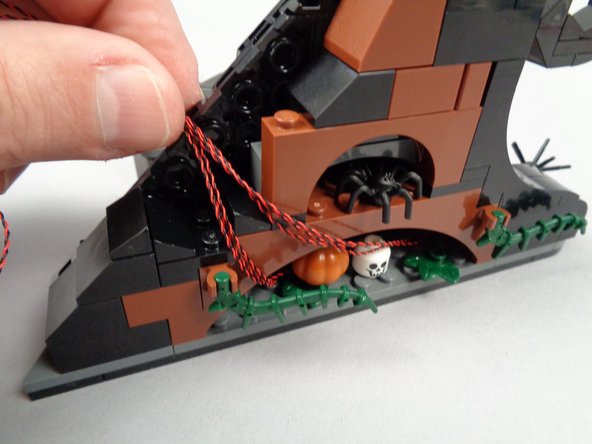 As shown in the first photo for this step, coil up the excess LED light wires into the space behind the front frame.