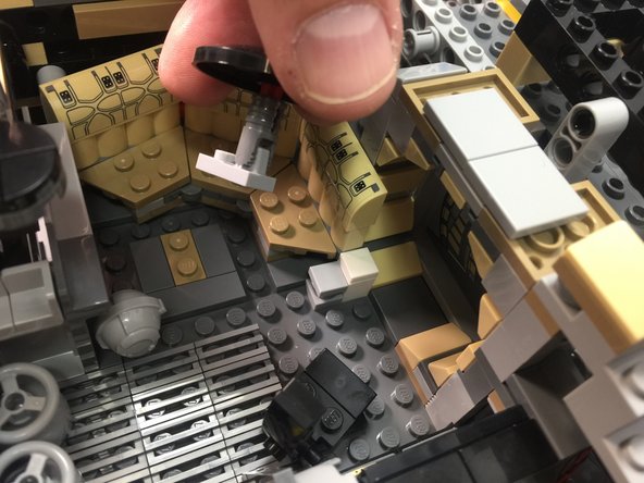 As shown in the photos for this step, remove the Dejarik holochess table from the front interior room, attach a Pico LED light to the underside using a small sticky square, and thread the LED light wire under the table and secure with the light bluish gray foot plate part.