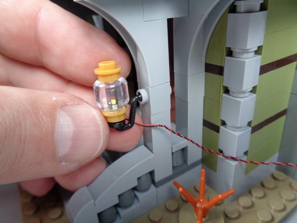 As shown in the first photo for this step, re-attach the first front porch light (on the right side of the front door).