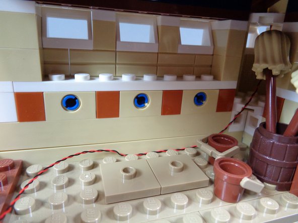 As shown by the orange arrow in the third photo, feed the light wire down underneath the floor in the spinning room.