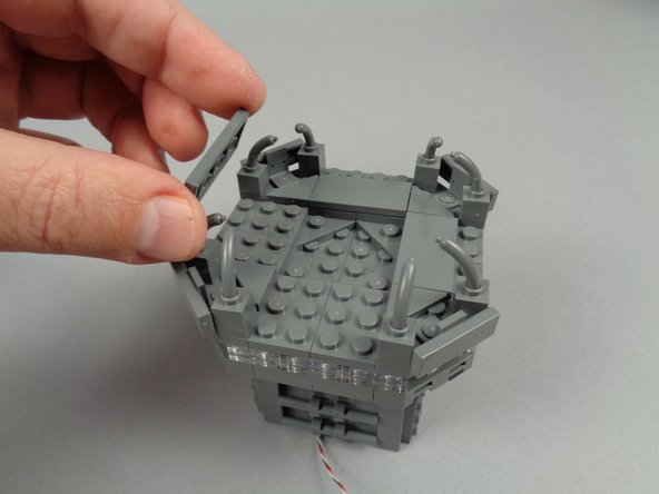 Finish re-assembling your broadcast tower by re-attaching the 2x4 LEGO tiles and fence pieces as shown in the first two photos for this step.