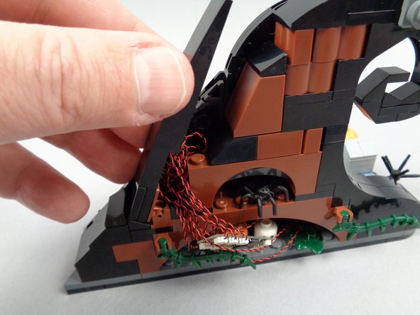 As shown in the first photo for this step, carefully re-attach the wave top slope section to the hinge.