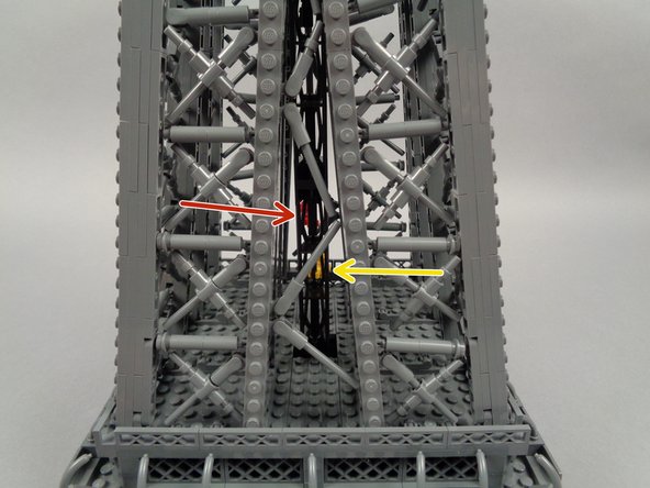 The red and yellow arrows in the second photo show the tower positioned with the two elevator cars facing away from the camera.