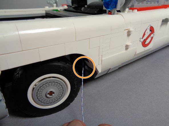 The orange circle in the third photo shows the hood spot light wire after it has been fully pulled out the side behind the front wheel.