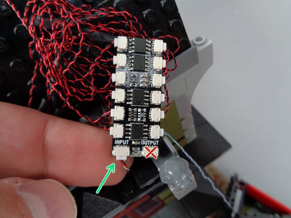 As shown by the green arrow in the second photo for this step, connect one end of this connecting cable to the plug on the BRANCH12X adapter board labeled INPUT.