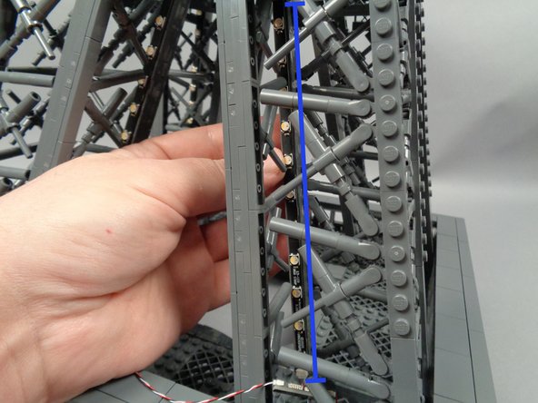 The yellow arrow in the first photo shows the small supporting piece for the horizontal walkway.  You can leave this in place, but be careful when passing the light strip beneath it.