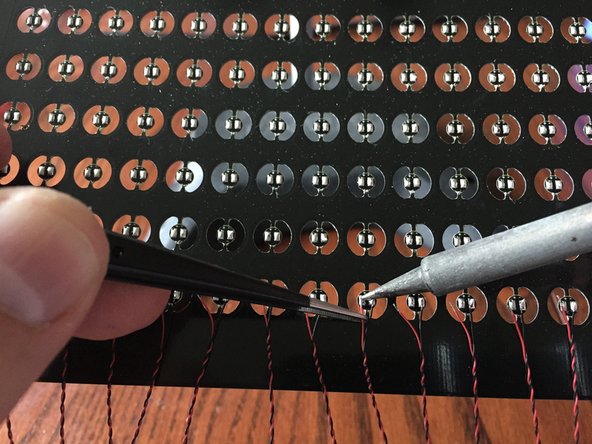 Using tweezers to hold the second wire, solder these to each LED board.