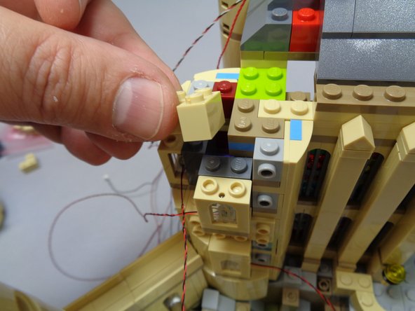 When you have re-attached all tan parts, you should have three light wires extending out the top of the tower as shown in the third photo.
