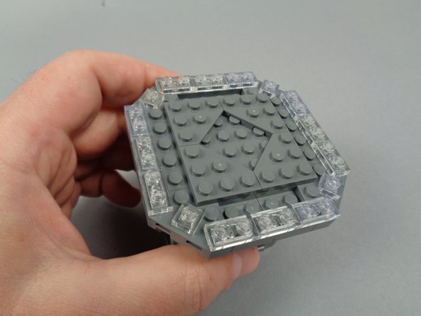 As shown in the photos for this step, continue disassembly by removing the eight 2x3 LEGO plates.