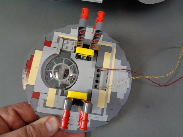 before re-attaching the laser cannon mount to the main frame, feed the laser light wires up into the main body of the Falcon.  Gently pull them as you re-attach the mount so there are no slack wires sticking out once the mount is fully re-attached.