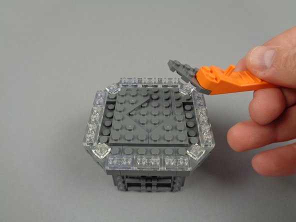 As shown in the photos for this step, continue disassembly by removing the four triangle/corner plates.