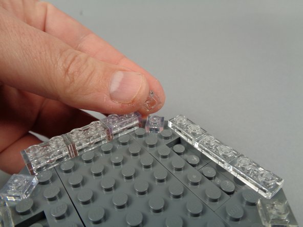 The green arrow in the third photo for this step shows the finished clear section, extending around the edge of the broadcast tower, now two plates in height.