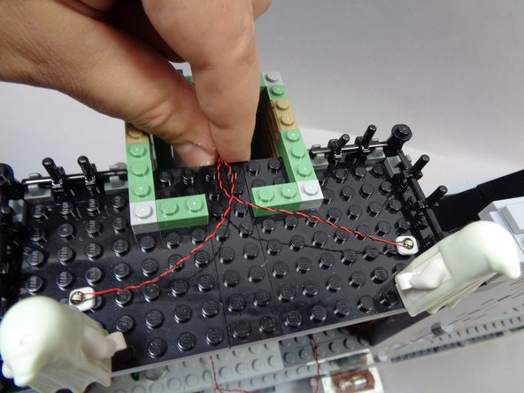 As shown in the second photo, stick the ultraviolet lights in front of the ghosts and run the light wires toward the center of the roof and down into the opening under the cupola.