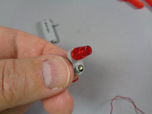 As shown in the first photo for this step, mount a second Red LED light in the other hole in the plate.