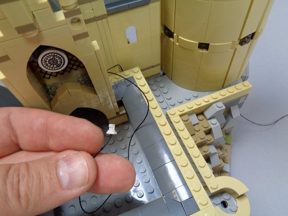 As shown in the second photo, remove the roof tile on the end of the courtyard, and feed the long black connecting cable through the window under the roof (see the red arrow).