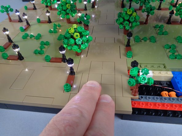 As shown in the second photo, carefully slide the small plate back into place, passing it underneath the lamp post you loosened.