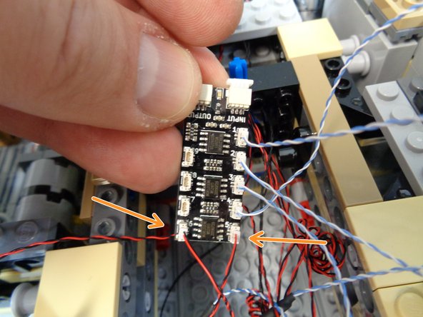 As shown by the two orange arrows in the photo for this step, connect the two computer LED lights to plugs #5 and #6 on the third BRANCH09X adapter board.