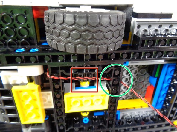 As shown by the green circle in the third photo, pass the two tail light wires through the hole in the black Technic frame and toward the BRANCH09X adapter.